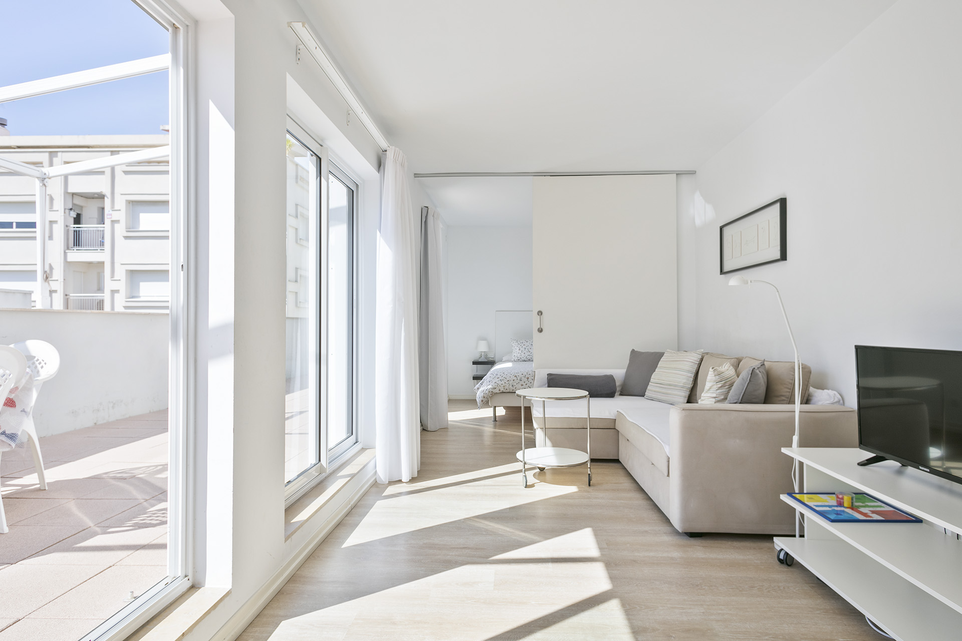 Sala d’estar lluminosa dels apartaments Pepita Bandert amb accés a la terrassa.